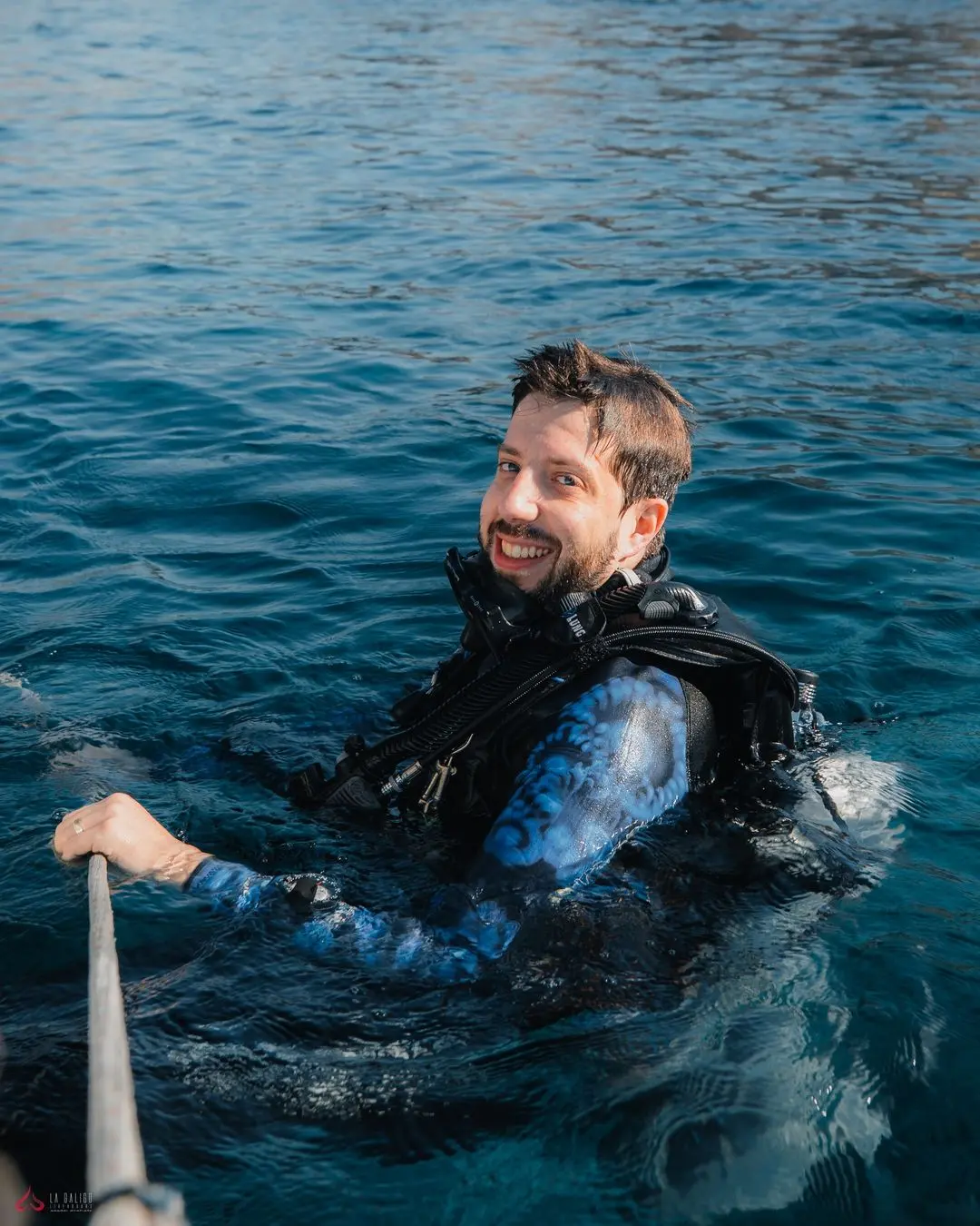 Content scuba diver relaxing on La Galigo's deck, reflecting on the day's underwater experiences
