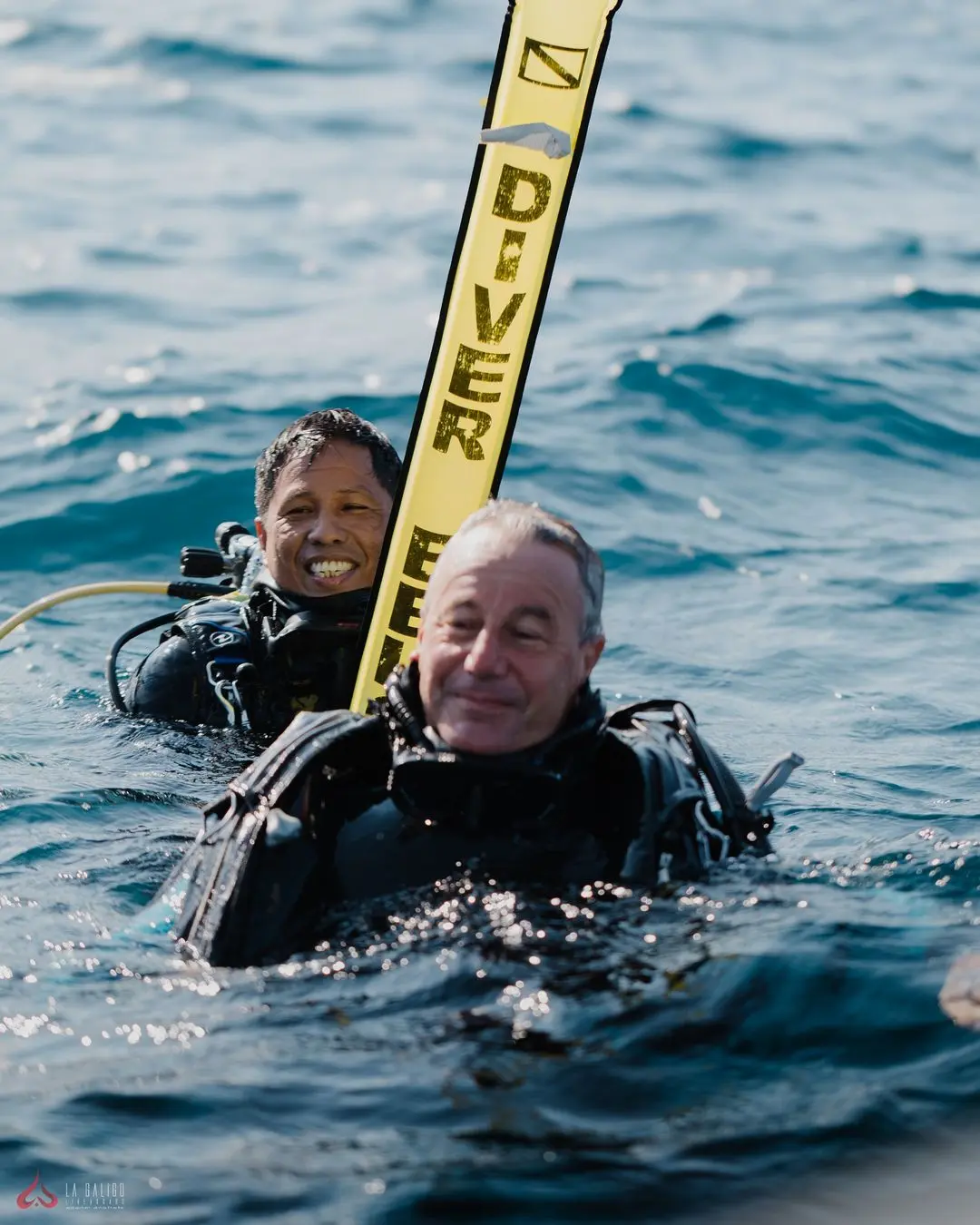 Scuba divers signaling with a surface buoy, awaiting pickup by La Galigo's tender boat.